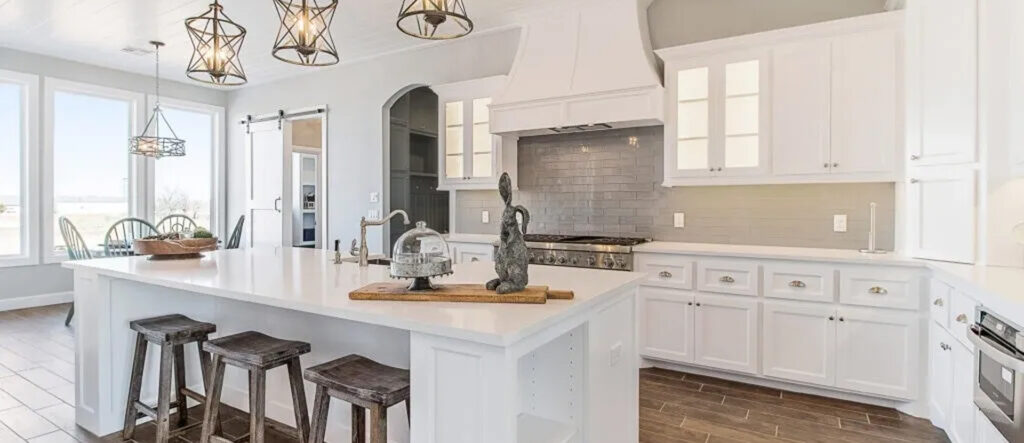Bright modern kitchen with white cabinets and island seating.