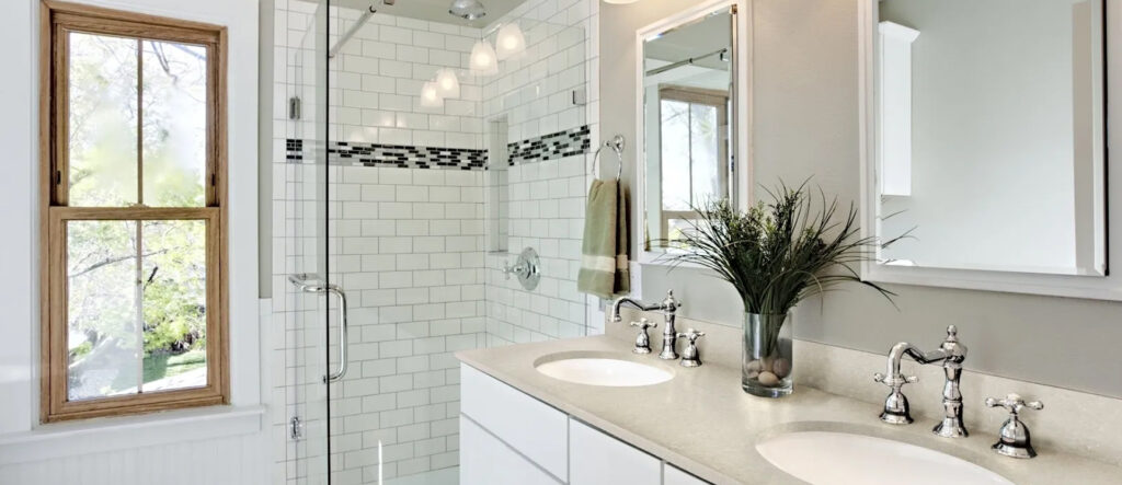 Modern bathroom with glass shower and white vanity.